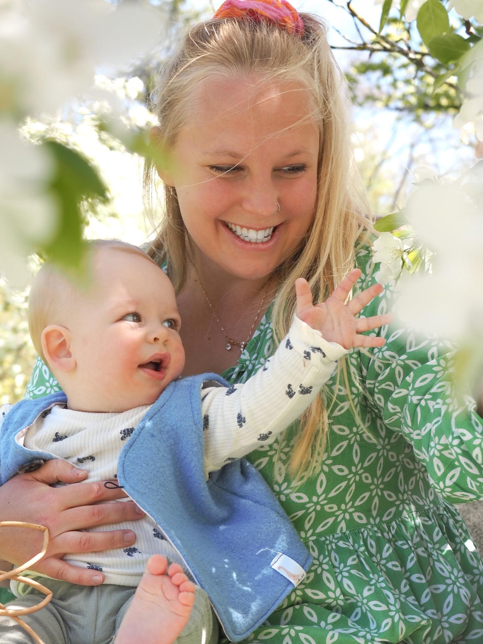 Baby mit Mutter zwischen Blüten